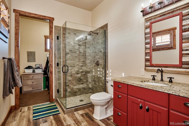 bathroom with walk in shower, vanity, toilet, and hardwood / wood-style floors