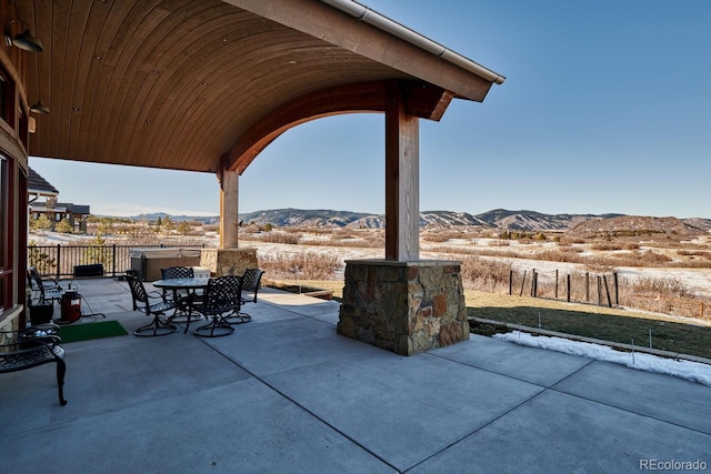 view of patio featuring a hot tub and a mountain view