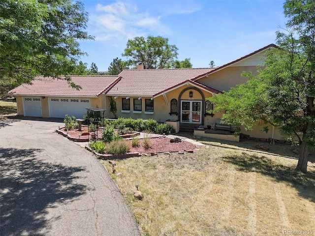 17852 E Long Ave, Centennial, CO 80016 - view of front of home with asphalt driveway, stucco siding, a chimney, a tile roof, and a garage
