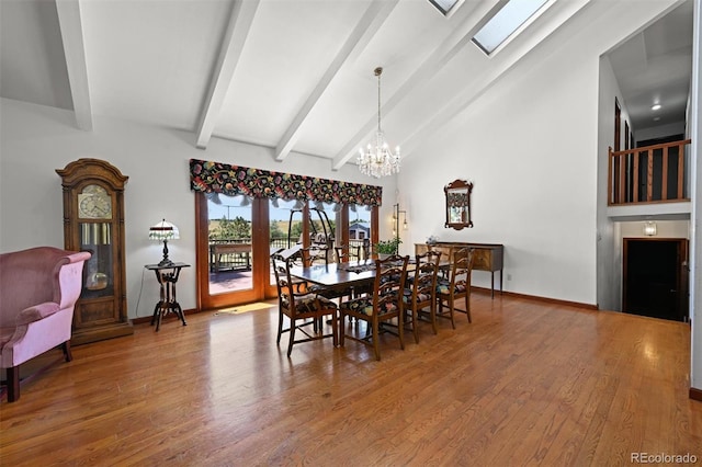 17852 E Long Ave, Centennial, CO 80016 - dining space with a chandelier, wood finished floors, beamed ceiling, a skylight, and high vaulted ceiling