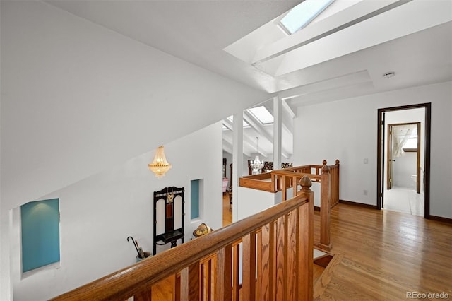 17852 E Long Ave, Centennial, CO 80016 - hallway featuring an upstairs landing, a chandelier, light wood finished floors, vaulted ceiling, and a skylight