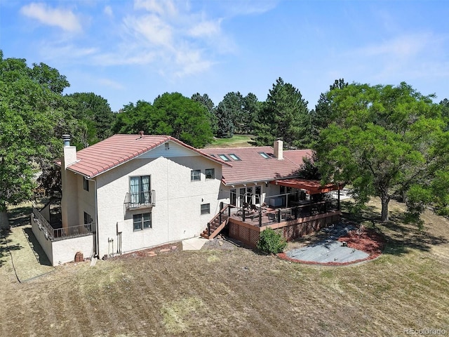 17852 E Long Ave, Centennial, CO 80016 - rear view of house featuring a tile roof, a deck, stucco siding, and a chimney