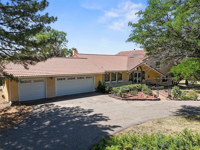 17852 E Long Ave, Centennial, CO 80016 - view of front of home featuring asphalt driveway, a tiled roof, stucco siding, a chimney, and an attached garage