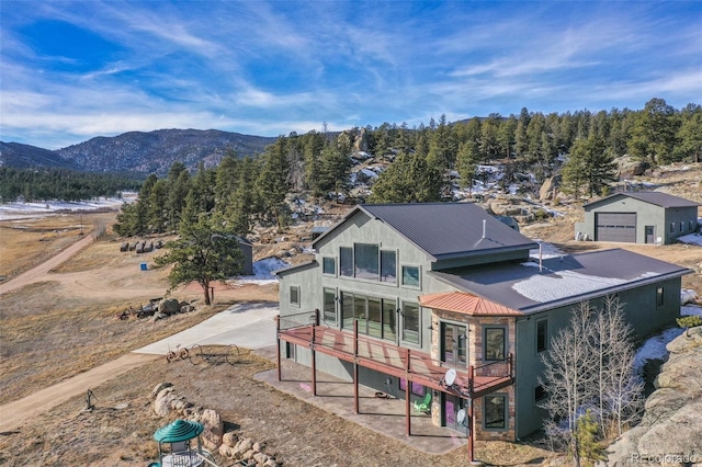 rear view of house featuring a mountain view and a garage