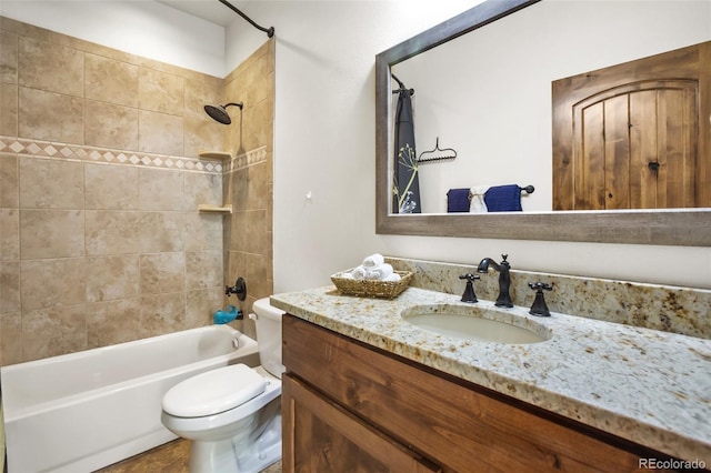 full bathroom featuring toilet, vanity, and tiled shower / bath