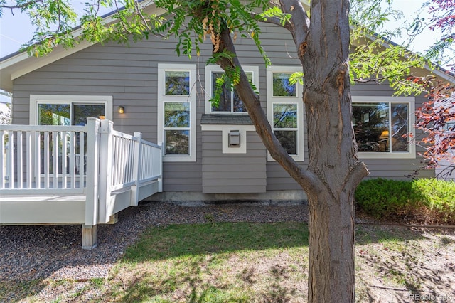 view of side of home featuring a wooden deck and a lawn