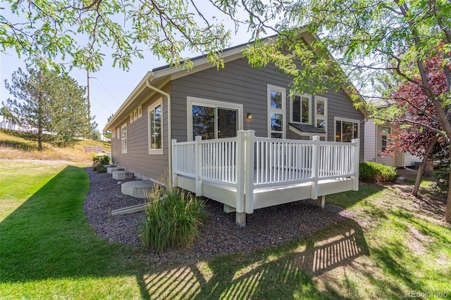 rear view of property with a lawn and a wooden deck