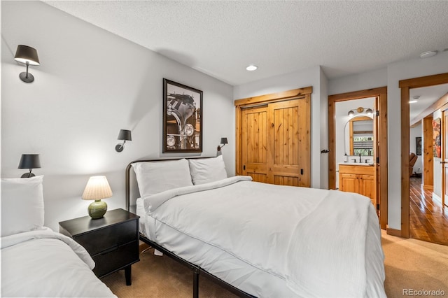 1655 Ranch Rd Unit 403, Steamboat Springs, CO 80487 - bedroom with a textured ceiling, carpet floors, recessed lighting, and connected bathroom
