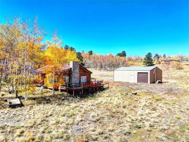 view of yard with an outbuilding, a deck, and a garage