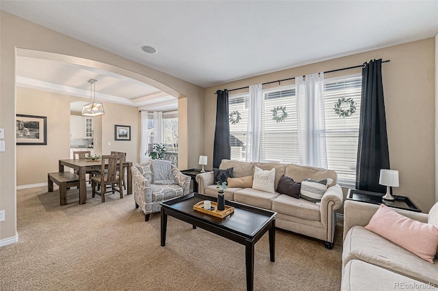 carpeted living room featuring a raised ceiling