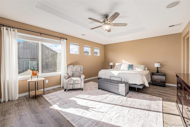 bedroom with a tray ceiling, ceiling fan, and hardwood / wood-style floors