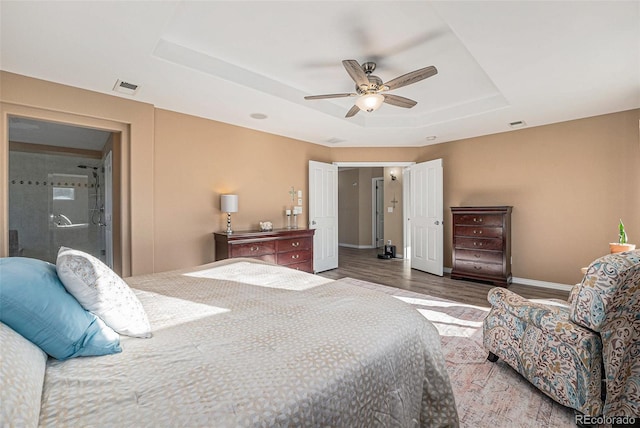 bedroom featuring a raised ceiling, ceiling fan, and dark wood-type flooring