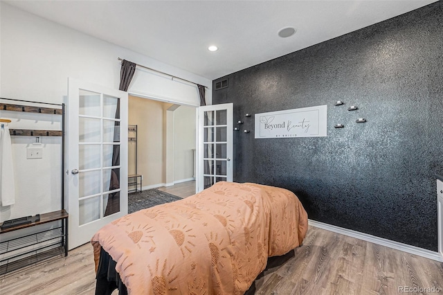 bedroom with wood-type flooring and french doors