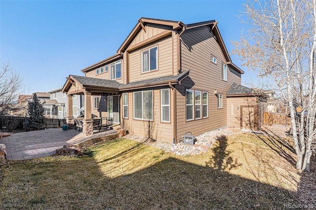 rear view of property with a yard and a patio