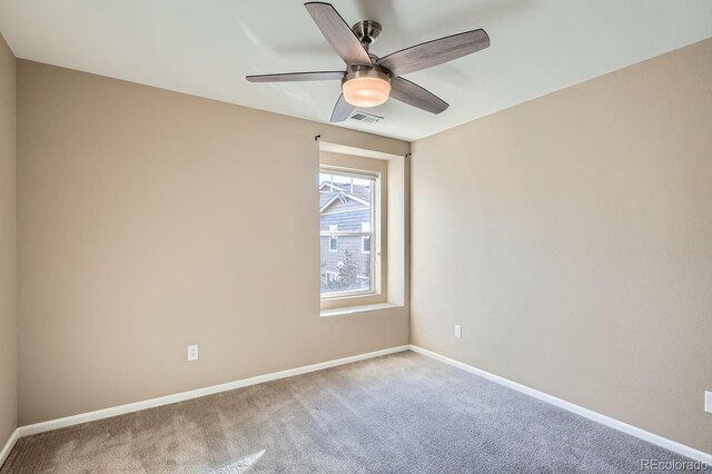 carpeted spare room with ceiling fan