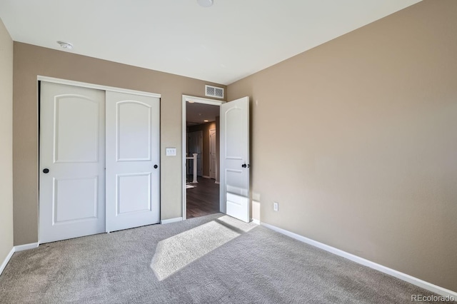 unfurnished bedroom featuring carpet and a closet