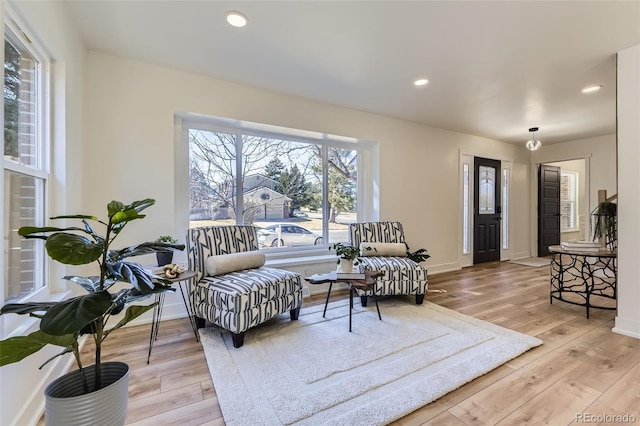 living area with light wood-style flooring, baseboards, and recessed lighting