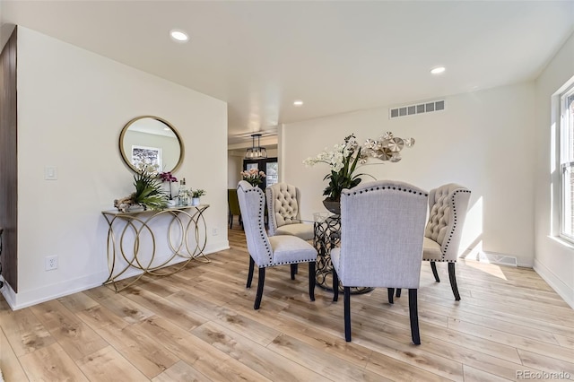 dining room featuring light wood finished floors, baseboards, visible vents, and recessed lighting