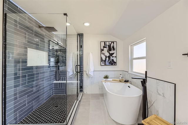 bathroom featuring a wainscoted wall, tile walls, a shower stall, tile patterned flooring, and a freestanding tub