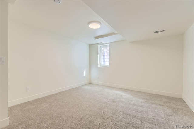 carpeted empty room with visible vents and baseboards