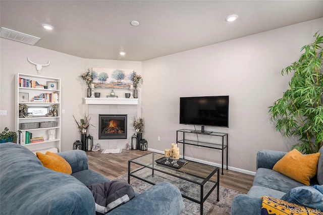 living room with wood-type flooring and a fireplace