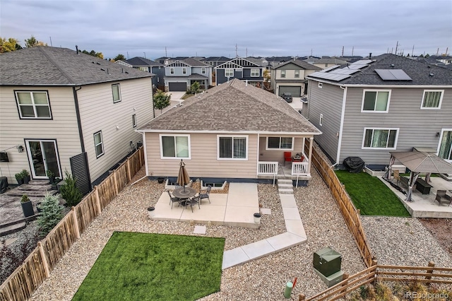 back of property with a gazebo, a patio area, and a lawn