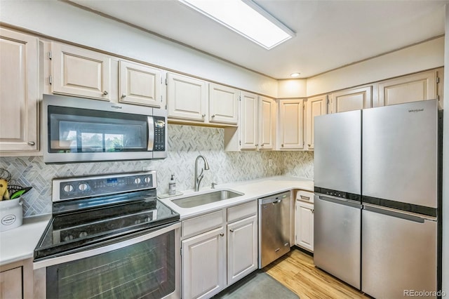 3240 Iris Ave Unit G409, Boulder, CO 80301 - kitchen featuring stainless steel appliances, a sink, light countertops, backsplash, and light wood-style flooring