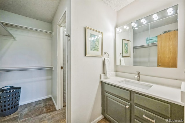 3240 Iris Ave Unit G409, Boulder, CO 80301 - bathroom with a textured ceiling, vanity, and baseboards