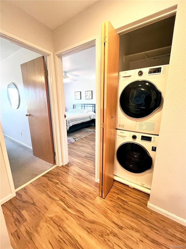 3240 Iris Ave Unit G409, Boulder, CO 80301 - laundry area with stacked washer / drying machine, wood finished floors, and baseboards