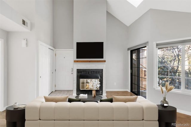 living room featuring a multi sided fireplace, high vaulted ceiling, and wood-type flooring