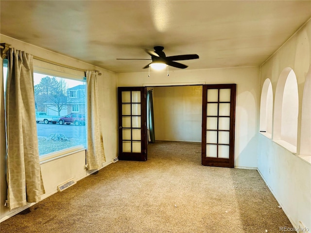 spare room with a ceiling fan, french doors, and visible vents