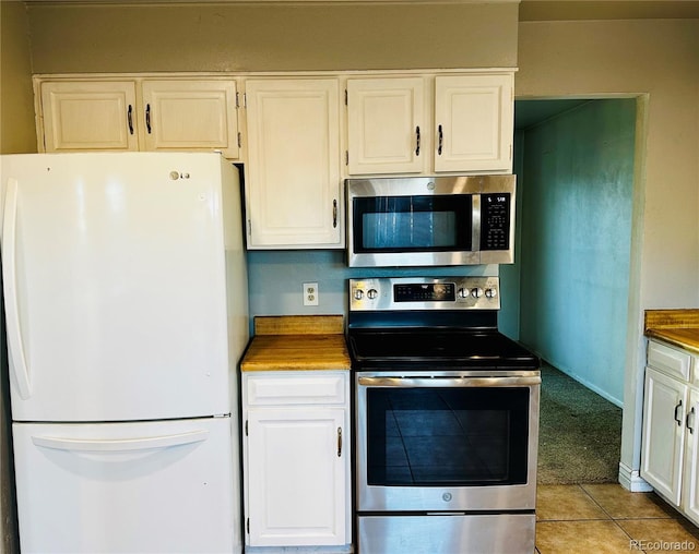 kitchen featuring white cabinets, light tile patterned floors, and stainless steel appliances