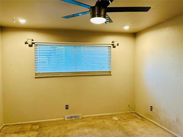 carpeted spare room featuring baseboards, a wealth of natural light, visible vents, and a ceiling fan