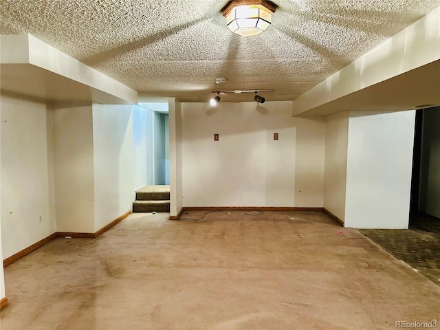 interior space featuring a textured ceiling, carpet floors, stairway, and track lighting