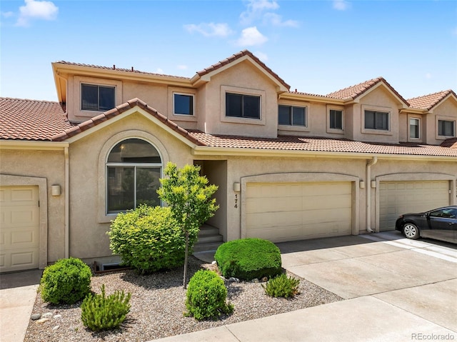 174 Luxury Ln, Colorado Springs, CO 80921 - townhome / multi-family property featuring stucco siding, a tile roof, driveway, and an attached garage