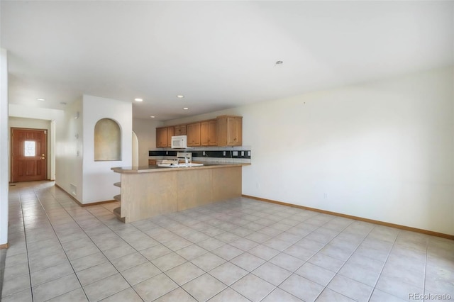 174 Luxury Ln, Colorado Springs, CO 80921 - kitchen with white microwave, a peninsula, range, recessed lighting, and light countertops