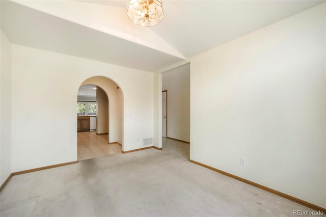 174 Luxury Ln, Colorado Springs, CO 80921 - spare room with arched walkways, light colored carpet, and vaulted ceiling