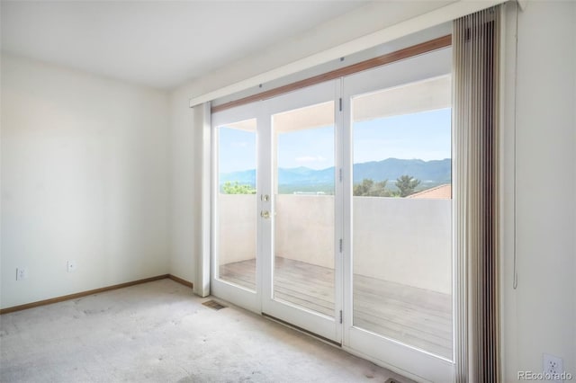 174 Luxury Ln, Colorado Springs, CO 80921 - empty room with light carpet, a mountain view, and french doors