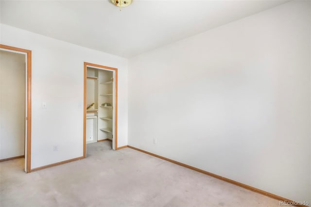 174 Luxury Ln, Colorado Springs, CO 80921 - unfurnished bedroom featuring light colored carpet, a walk in closet, and a closet