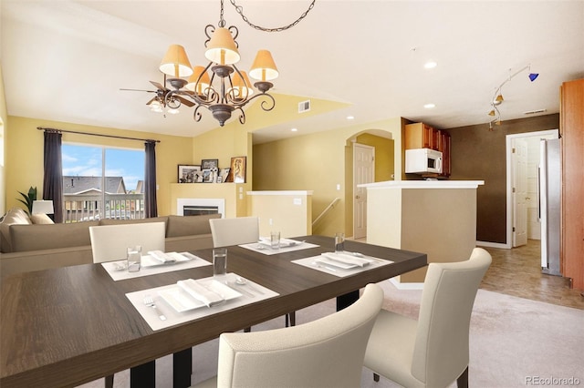 9311 Amison Cir Unit 204, Parker, CO 80134 - dining area featuring arched walkways, a chandelier, a glass covered fireplace, lofted ceiling, and recessed lighting
