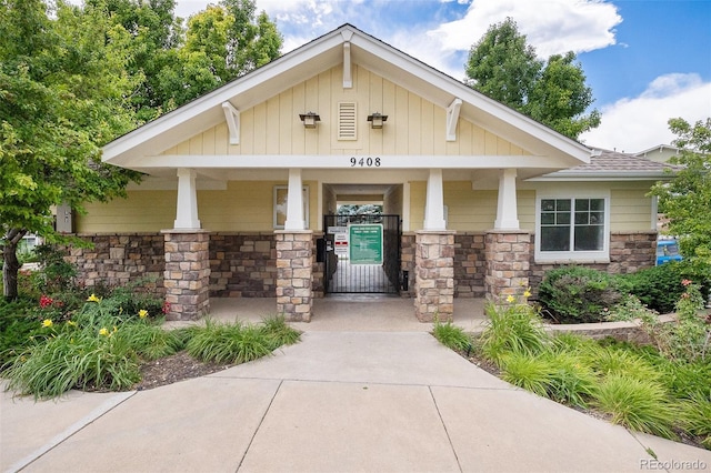 9311 Amison Cir Unit 204, Parker, CO 80134 - view of front of home with stone siding, a porch, board and batten siding, and a shingled roof