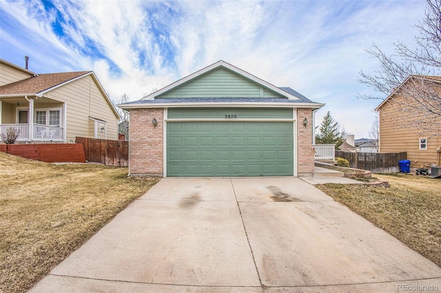 2870 Harrisburg Way, Colorado Springs, CO 80922 - view of front of property with concrete driveway, fence, a front lawn, and brick siding