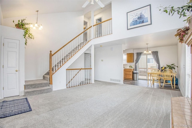 2870 Harrisburg Way, Colorado Springs, CO 80922 - unfurnished living room featuring a chandelier, stairs, visible vents, high vaulted ceiling, and carpet