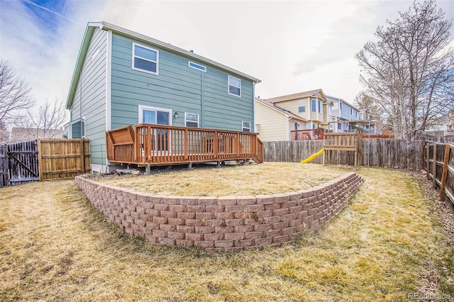 2870 Harrisburg Way, Colorado Springs, CO 80922 - rear view of house with a deck, a fenced backyard, and a lawn