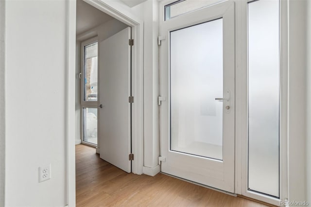 hallway featuring light wood-style floors and a wealth of natural light