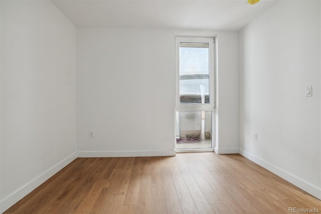 unfurnished room featuring baseboards and light wood finished floors