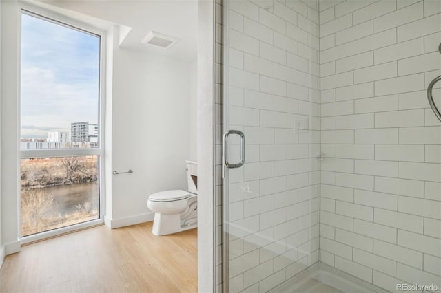 full bathroom with visible vents, baseboards, toilet, a stall shower, and wood finished floors