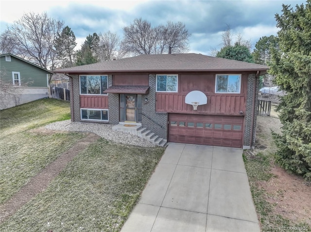 raised ranch with a front yard, fence, concrete driveway, a garage, and brick siding