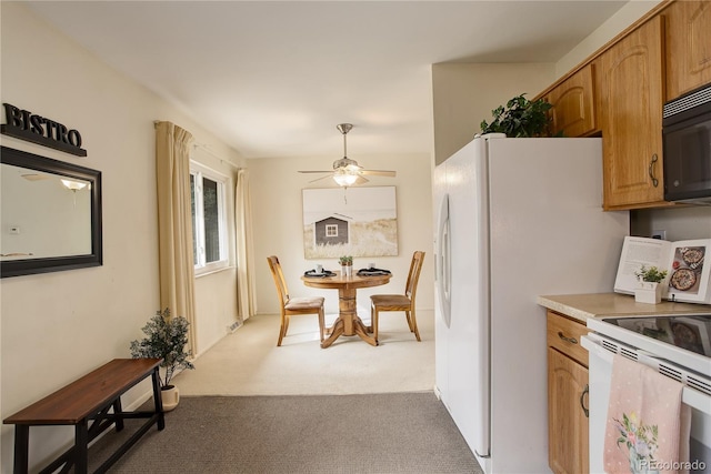 kitchen featuring ceiling fan, black microwave, light countertops, carpet flooring, and white electric range oven