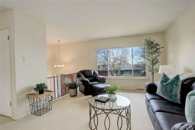 living room featuring an inviting chandelier, carpet flooring, and visible vents